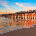 Incoming tide reflects the sunsent at Balboa Pier in Newport Beach, CA